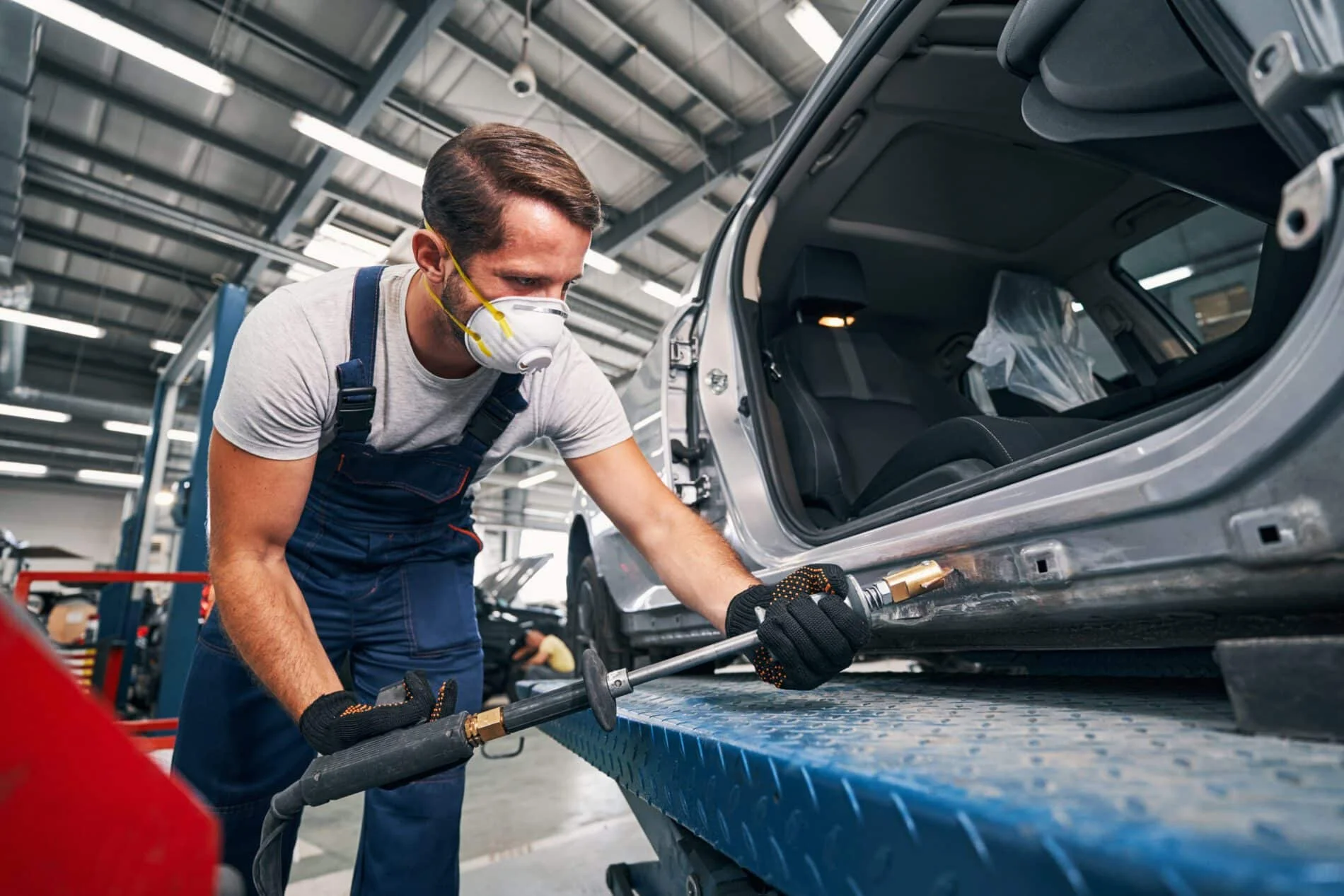 mechanic removing dents from rear part of car 2023 11 27 05 31 01 utc scaled The No.1 Best Collision Repair in Irving TX- Carmex Inc.