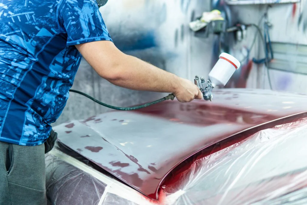 auto mechanic painting a red car in a workshop 2023 11 27 05 30 22 utc No.1 Best Expert in Auto Body Repair Irving TX- Carmex Inc.